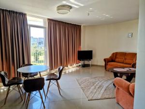 a living room with a couch and a table and chairs at Vienas po kitu in Šventoji