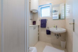 a white bathroom with a sink and a mirror at PODVEZANEC in Dramalj +126 photos