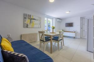 a living room with a table and chairs and a couch at PODVEZANEC in Dramalj