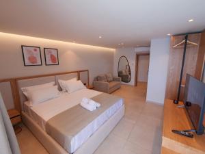una camera da letto con un letto grande e una televisione di Sunrise Qeparo a Qeparo