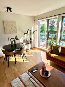 een woonkamer met een tafel en een bank bij Top floor apartment with mountain view, terrace 22sqm, free parking in Bergen