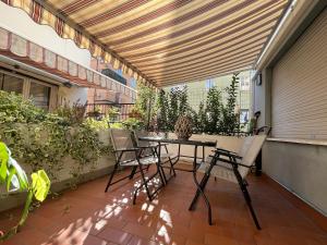 梅斯特Thalia Room Venezia Mestre的阳台上配有桌椅的露台