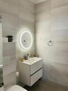 a bathroom with a white sink and a mirror at Amely Apartments 305 by Wave Residence in Mamaia Nord