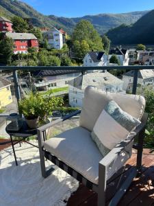 een stoel op een balkon met uitzicht op de stad bij Top floor apartment with mountain view, terrace 22sqm, free parking in Bergen