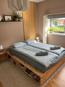 een slaapkamer met een houten bed met kussens erop bij Top floor apartment with mountain view, terrace 22sqm, free parking in Bergen
