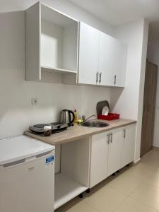 a kitchen with white cabinets and a sink at Apartments Drini in Ulcinj +21 photos