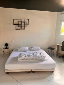 アンデルノ・レ・バンにあるvilla patio proche centre villeのベッドルーム1室(白いベッド1台、シャンデリア付) +10枚の写真