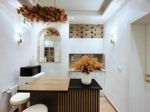 梅斯特Thalia Room Venezia Mestre的厨房配有白色橱柜和花瓶桌子