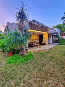 a house with a palm tree in front of it at La Shangrila Charming City Center Villa in Ahmedabad