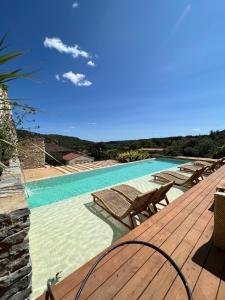 a swimming pool with chairs and a wooden deck at Mas Beauregard in Anduze +42 photos