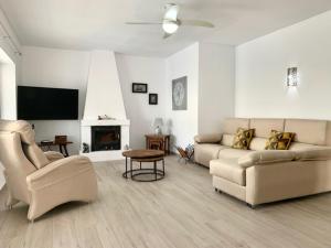 a living room with a couch and a tv at Casa Tia, Mojácar with Private Pool and less than 5 minutes from beach! in Mojácar