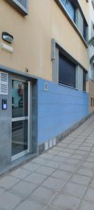 un edificio con un muro blu accanto a un marciapiede di Cosy Apartment at Sardina Beach a Sardina