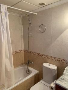 a bathroom with a shower and a toilet and a tub at Buganvillas Urbanisation House Facing Pool in Vera