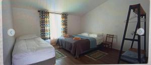 a small bedroom with a bed and a ladder at Guest House Shina in Omalo