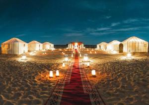 un tappeto rosso nel mezzo di un deserto di notte di Saffron Heritage Desert Camp a Jaisalmer