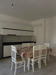 a dining room with a table and four chairs at Il Sol Apartment in Lezhë +3 photos