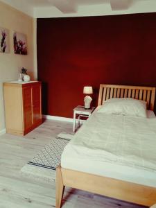 ein Schlafzimmer mit einem großen Bett und einer roten Wand in der Unterkunft Gäste- und Monteurwohnung alte Gärtnerei in Kalefeld