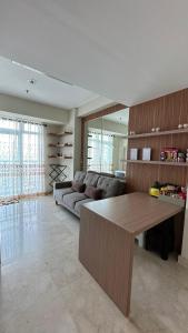 a living room with a couch and a table at Apt Puri Orchard at puri in Jakarta +6 photos