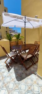 een tafel en stoelen met een parasol op een terras bij Casa da Açoteia - Bright City Center Apartment with a Private Outdoor Terrace in Faro