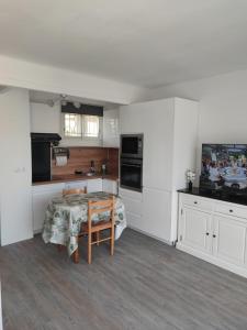 圣拉斐尔Studio Cosy vue Mer à deux pas du Port Santa Lucia - Saint Raphael的厨房配有白色橱柜和桌子
