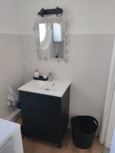 圣拉斐尔Studio Cosy vue Mer à deux pas du Port Santa Lucia - Saint Raphael的浴室设有黑白水槽和镜子 更多5张照片