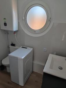 圣拉斐尔Studio Cosy vue Mer à deux pas du Port Santa Lucia - Saint Raphael的一间带卫生间的浴室和圆形窗户。