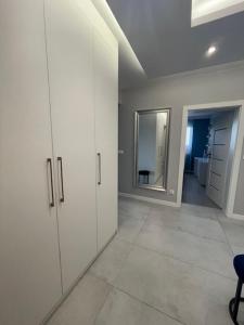 een kamer met een hal met witte kasten en een spiegel bij AK Apartamenty Centrum in Białystok