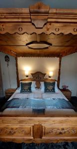 een groot houten bed in een slaapkamer met 2 lampen bij Hotel Kirchbühl im Schwarzwald Hôtel in Schönau im Schwarzwald