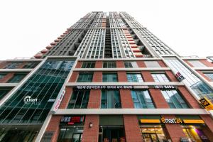 a tall red brick building with a lot of windows at High floor view accommodation in Busan