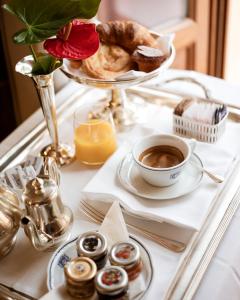 a tray with a cup of coffee and pastries on a table at Grand Hotel Bellavista Palace & Golf in Montecatini Terme