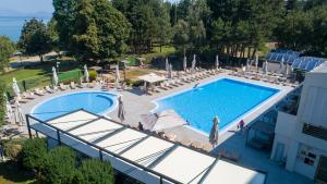 an overhead view of a swimming pool with chairs and umbrellas at Hotel Bellevue - Metropol Lake Resort in Ohrid