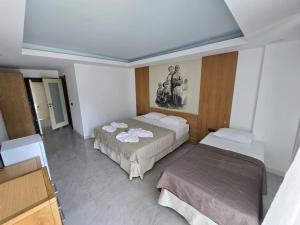 a room with two beds in a room with at Gül Otel in Belek +6 photos