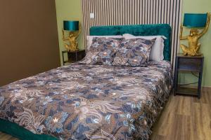 Un dormitorio con una cama y dos mesitas de noche con lámparas. en Coin de nature en centre-ville, en Troyes