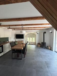 a kitchen and dining room with a table and chairs at Dom w lesie in Dzbądzek