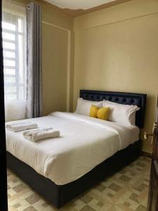 a bedroom with a large bed with towels on it at Rembeka furnished apartments in Naivasha