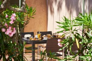 a table with food and drinks on it with plants at Les Maisons Du Sud in Saint-Tropez