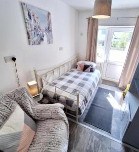 a bedroom with two beds and a couch at Beautiful 2 bedroom annexe in popular town location in Pembrokeshire