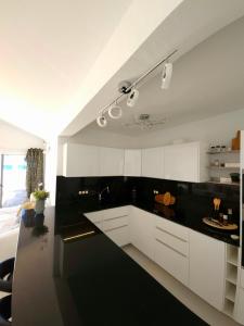 a kitchen with white cabinets and a black counter top at Blue Miracle Villa in Arrecife