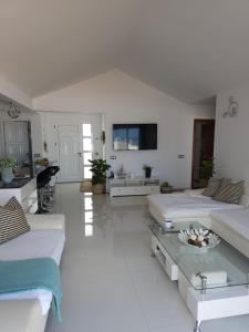 a white living room with two beds and a table at Blue Miracle Villa in Arrecife