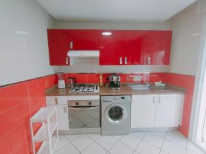 a kitchen with red cabinets and a washing machine at Warda luxury home in Martil