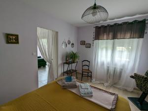 Un dormitorio con una cama y una habitación con ventana. en La Maison sous l'olivier, en Morières-lès-Avignon