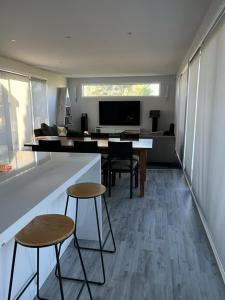 a living room with a table and two stools at Ocean Beach Paradise in Tairua