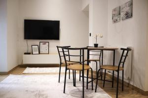 een eetkamer met een tafel, stoelen en een tv bij Apartman A in the heart of Ferhadija - Parking available in Sarajevo