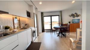 a kitchen and living room with a table and chairs at ImoWeMo OVAR - Ovarinha Girassol in Ovar