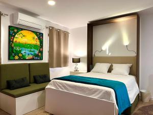 a bedroom with a bed and a painting on the wall at ImoWeMo OVAR - Ovarinha Girassol in Ovar