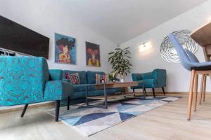 a living room with a blue couch and a table at Lak-Lak Vendégház in Nagykanizsa