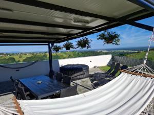 a hammock on a patio with a table and chairs at Kuća za odmor KODBA in Štrigova