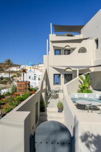 a white building with a balcony with tables and chairs at Galaria Serenity Suites in Vóthon