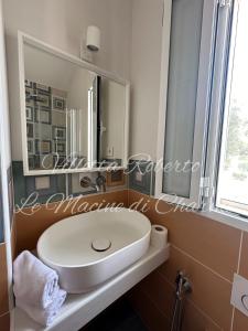 a bathroom with a white sink and a mirror at Villetta Roberto Le Macine di Charme - Pugnochiuso Resort in Vieste