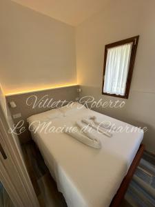 a bedroom with a bed with a mirror and a window at Villetta Roberto Le Macine di Charme - Pugnochiuso Resort in Vieste